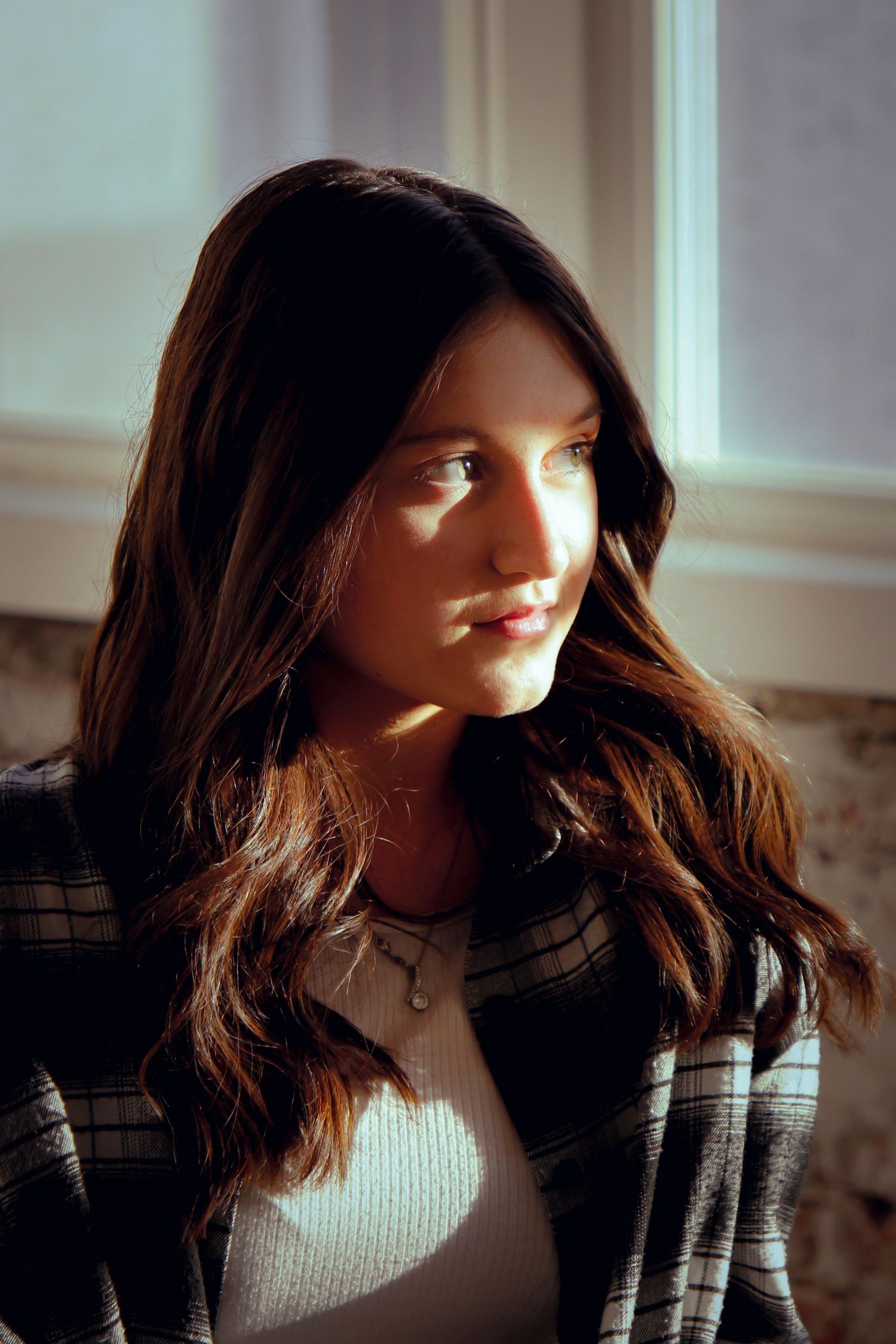 Portrait in natural window light wearing plaid jacket.