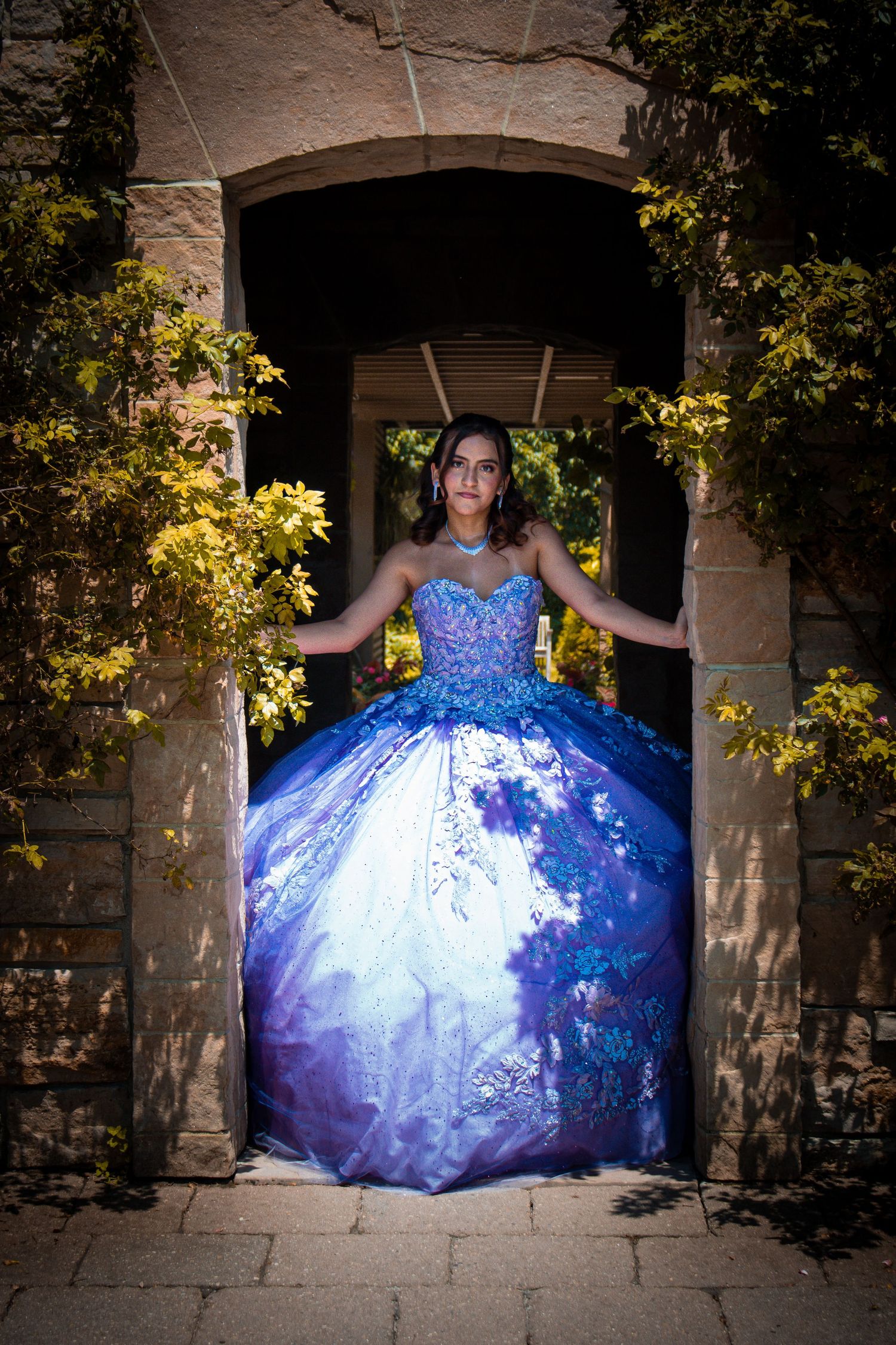 Professional special event photography.  Girl in quinceanera dress in outdoor garden location.