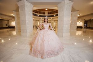 Ethereal pink ball gown with floral details in an elegant marble hallway.