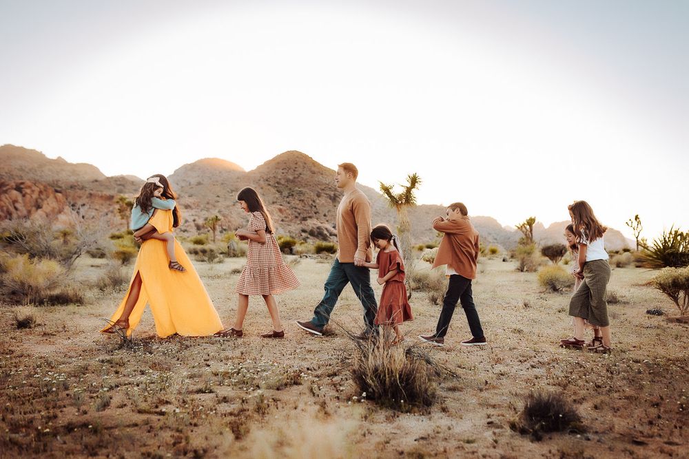 Family of eight gathered in the Joshua Tree desert, celebrating togetherness with a scenic backdrop.