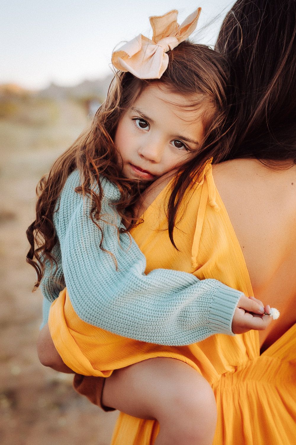 Adorable toddler posing in the Joshua Tree desert, smiling in natural sunlight with a mountain backdrop