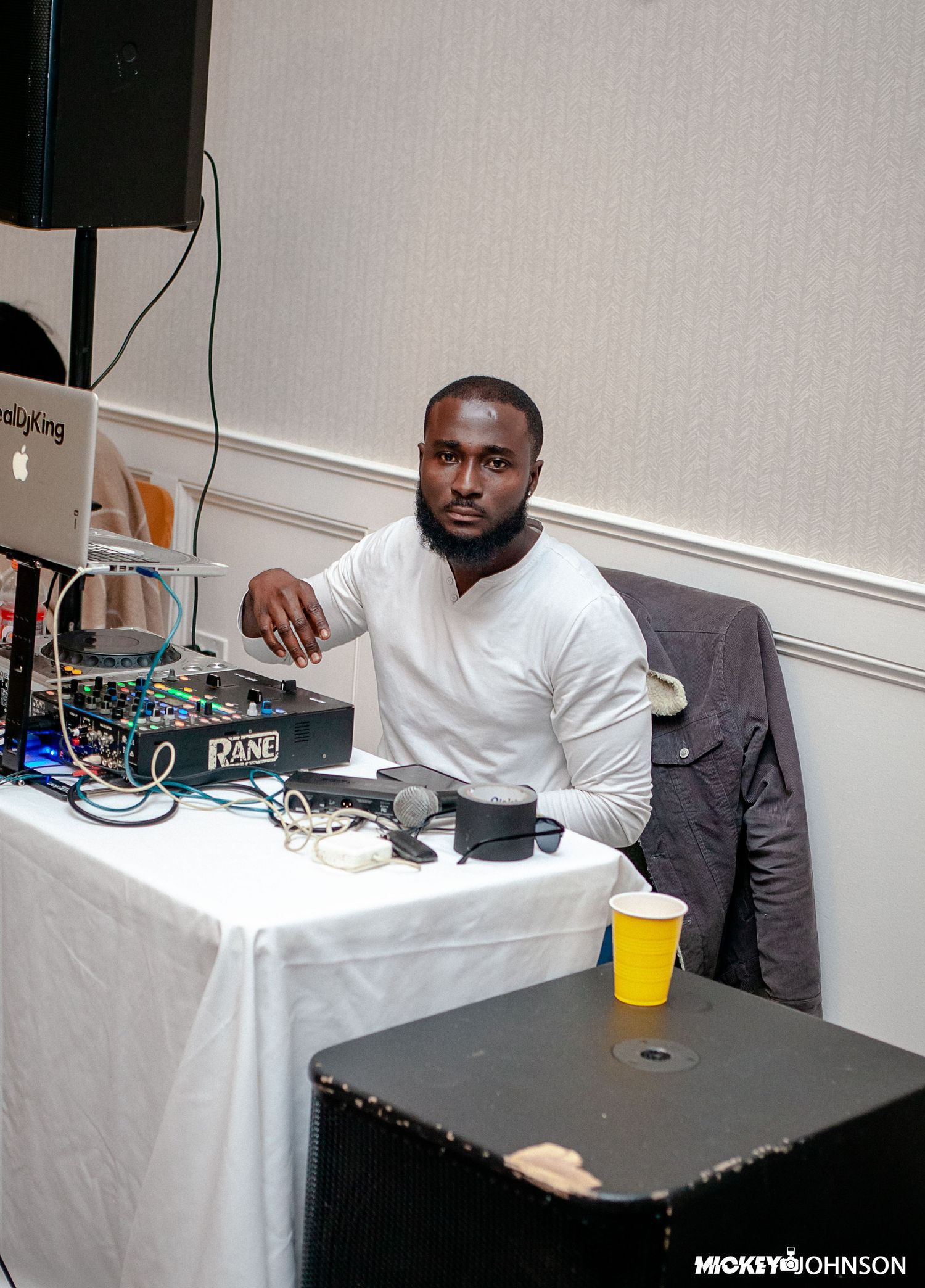 DJ setup with equipment and mixing board at an event venue.