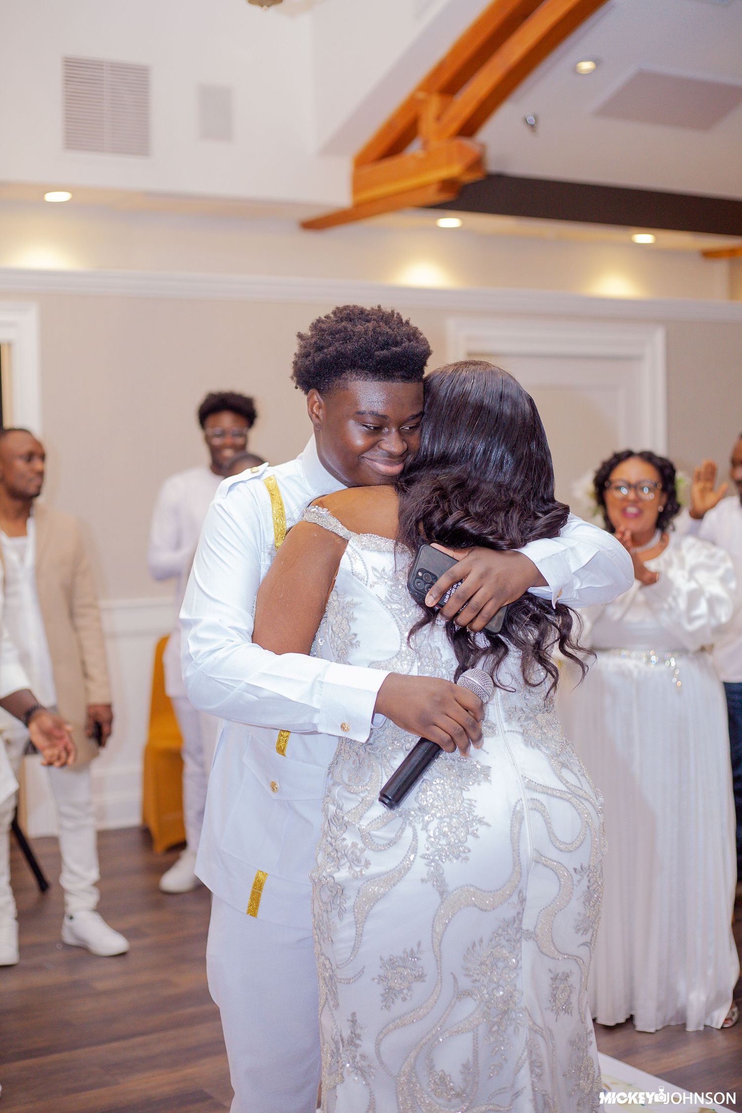 A tender moment shared during a dance at an elegant white-themed celebration.