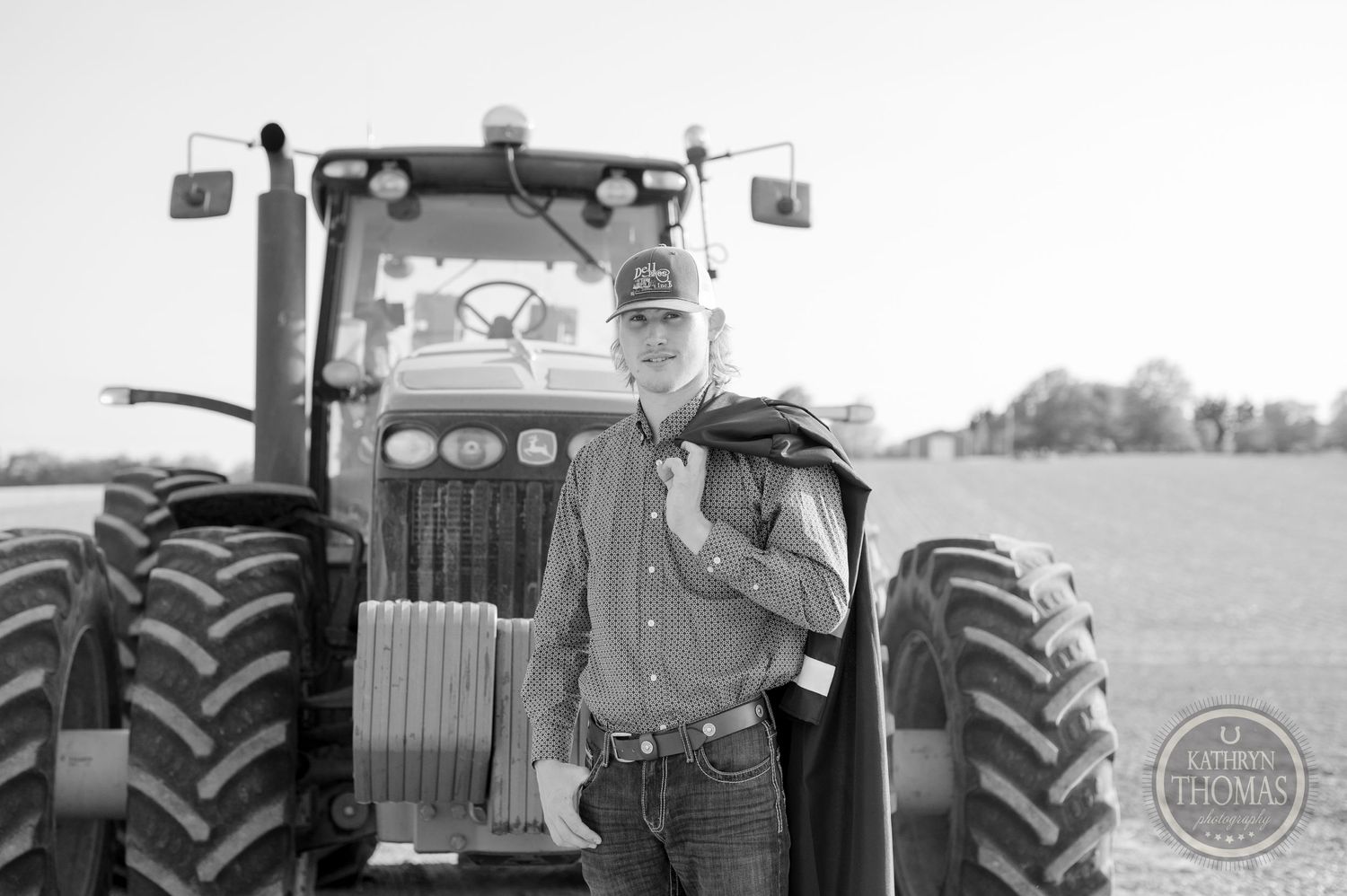 Black and white portrait with farm tractor in agricultural setting.