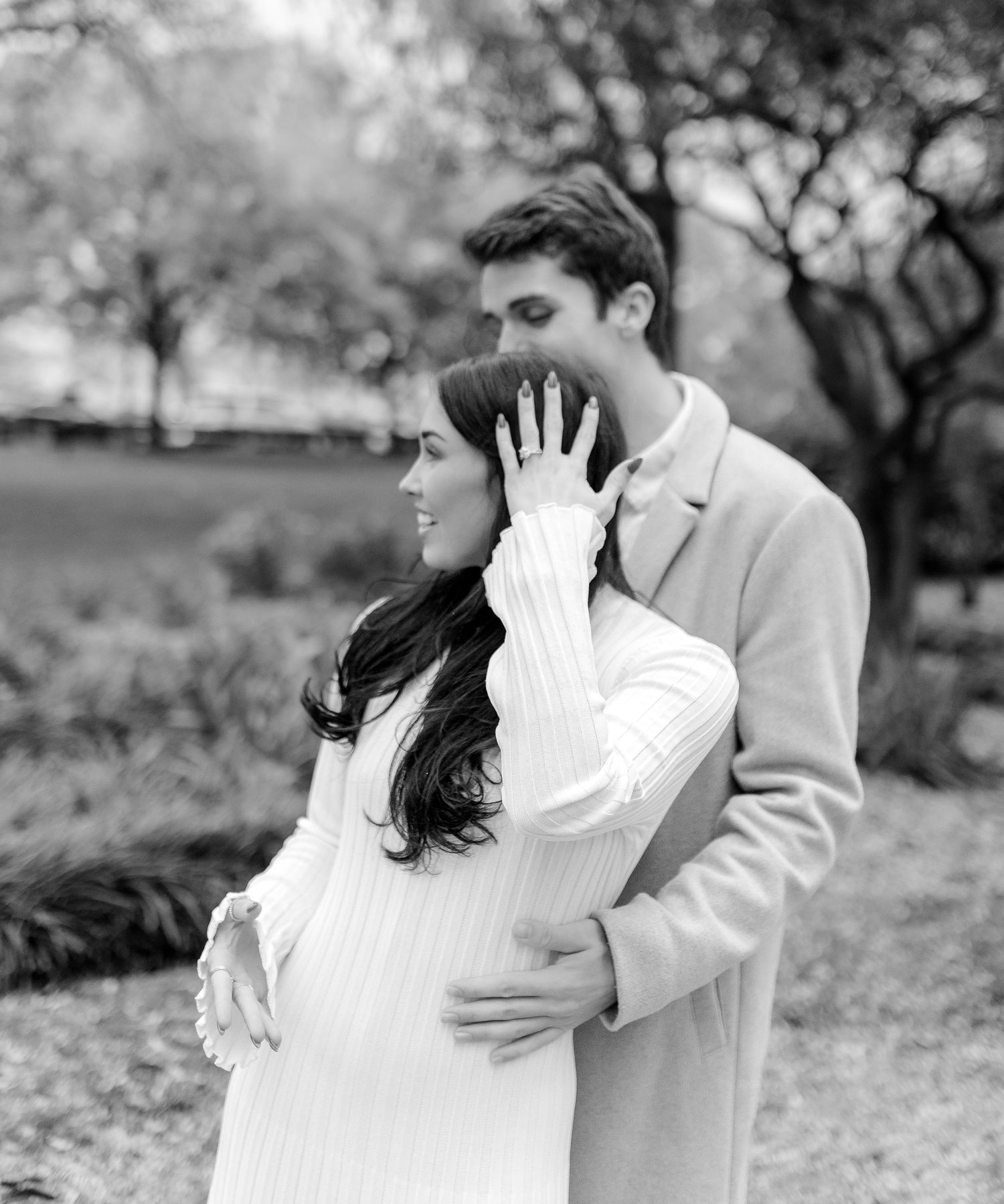 A romantic black and white moment captured in an outdoor garden setting.