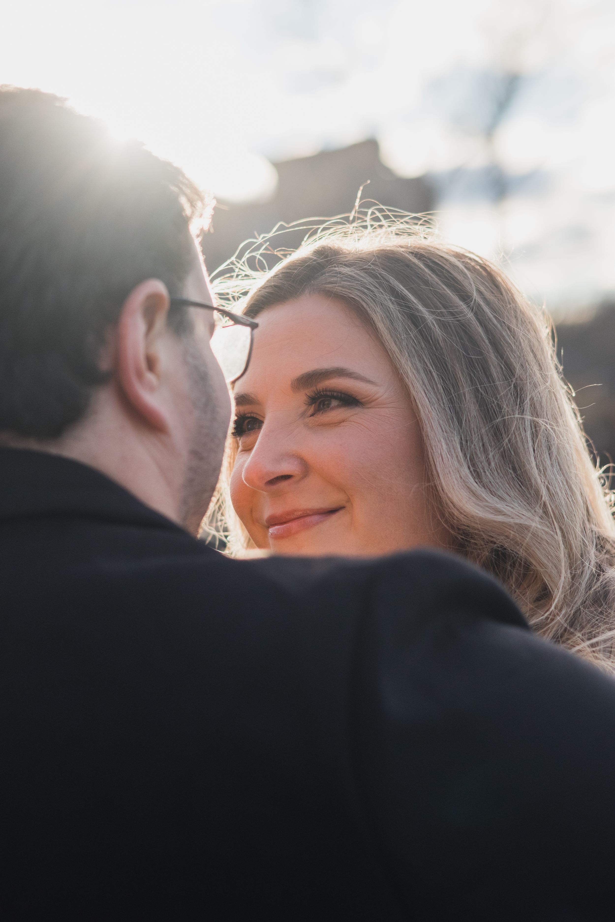 A romantic couple shares an intimate moment in golden sunlight during a wedding photoshoot.