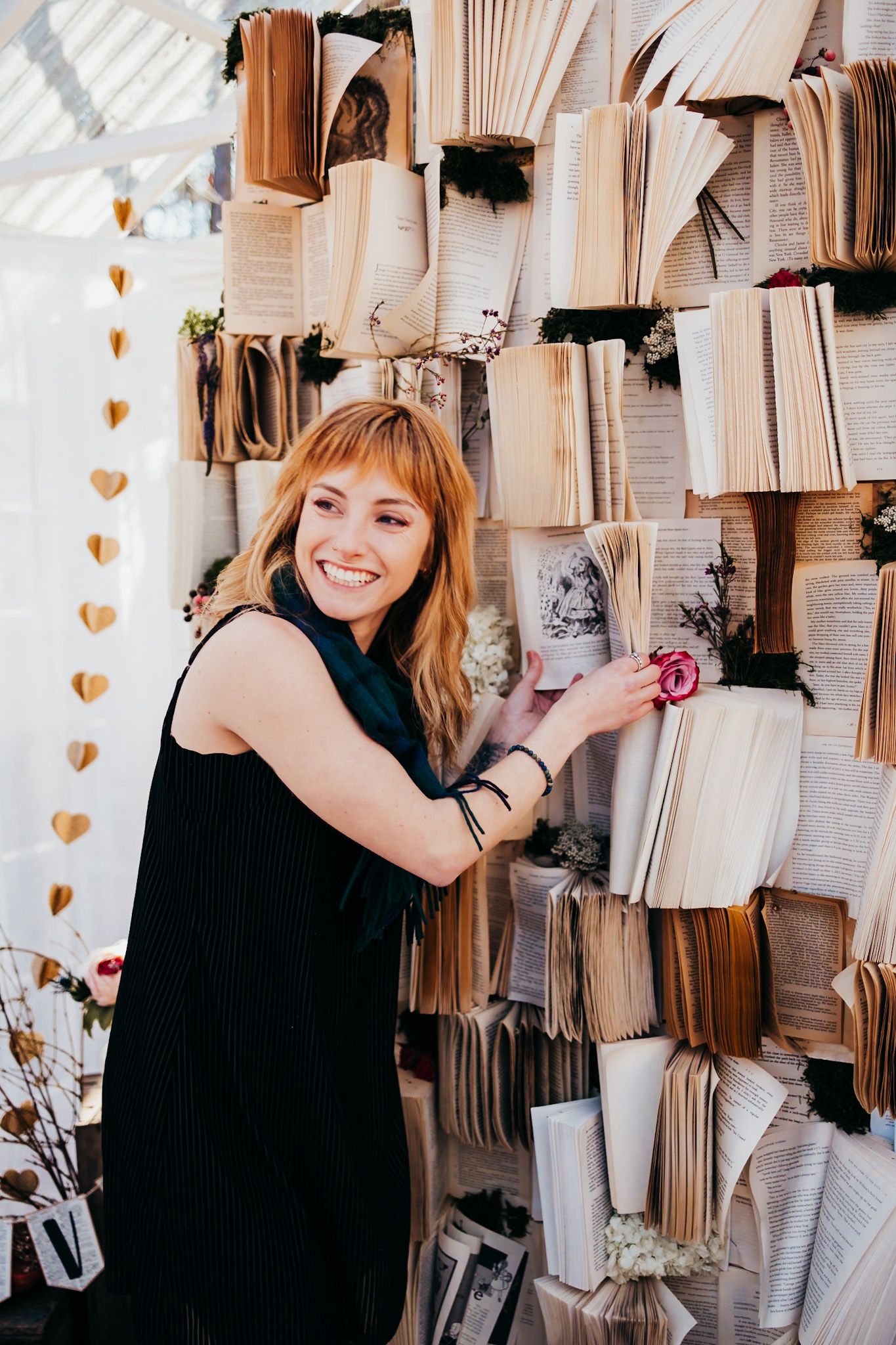 red haired girl laughing in front of a book wall