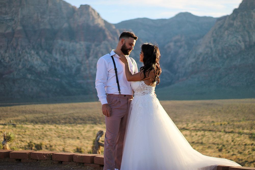 Bride and groom share romantic moment at Red Rock Canyon desert wedding venue at sunset.