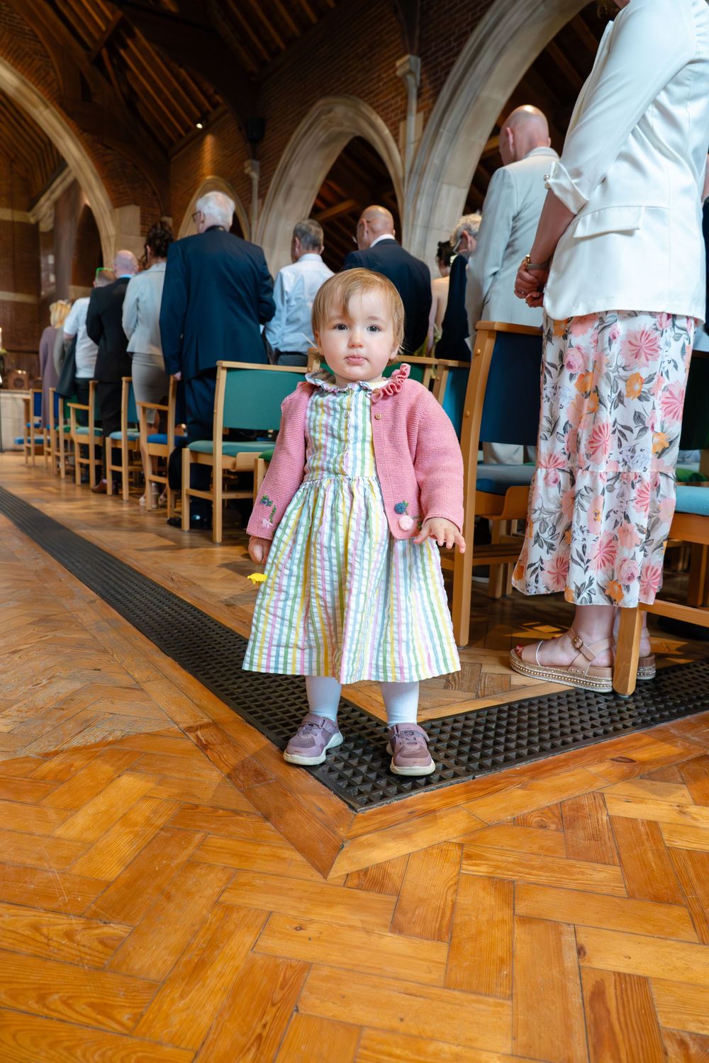 A little girl who is a wedding guest during the wedding ceremony in a beautiful church in Cheshire.