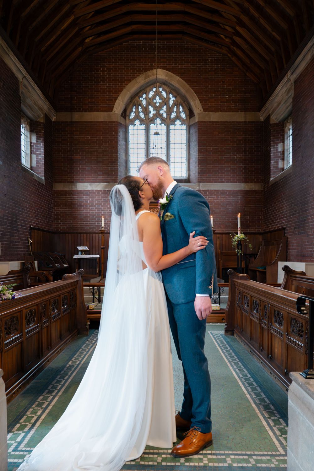A couples first kiss as the vicar pronounces them husband and wife during their wedding ceremony at St Oswalds church, Bollington, Cheshire.