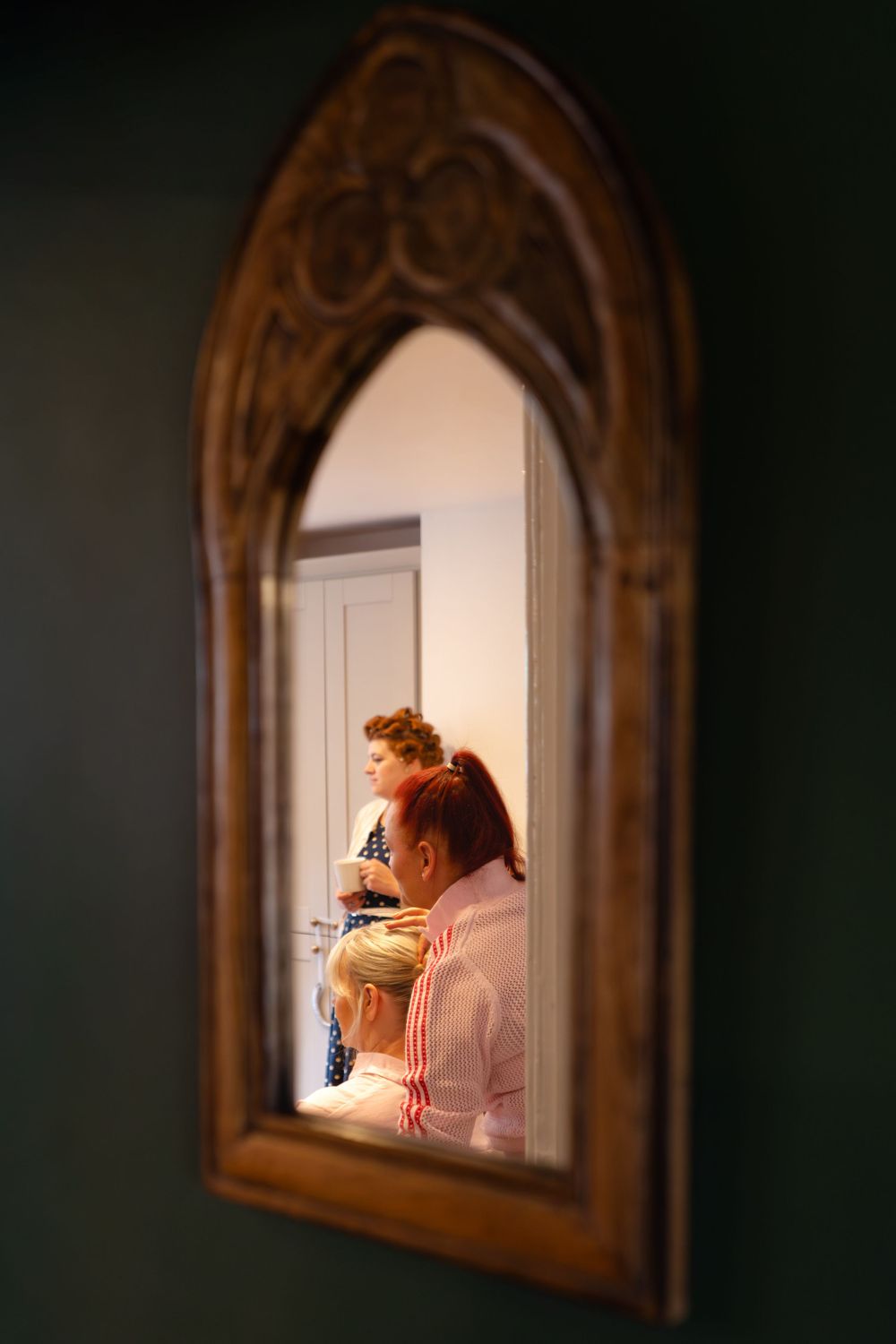 In a mirror is the reflection of the bridal party getting ready for a wedding in the Cheshire countryside.