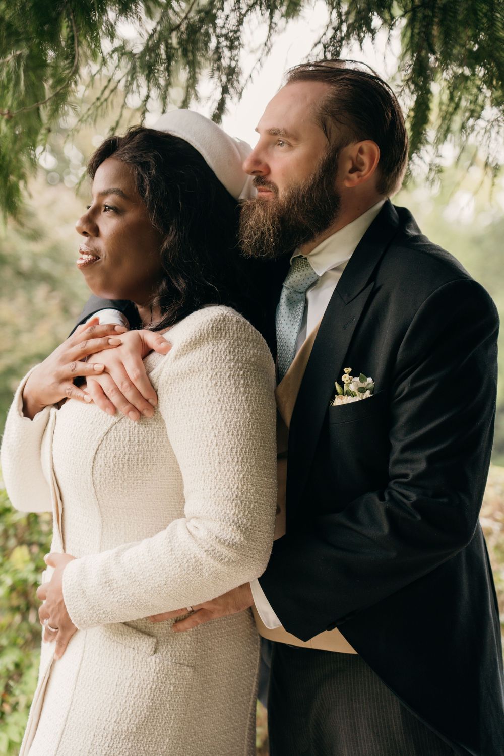 the newly wed couple in a gentle embrace while looking into the distance during their couples photoshoot.