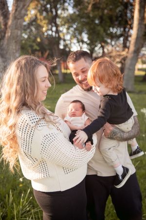 Family sharing tender moment outdoors in natural sunlight.
