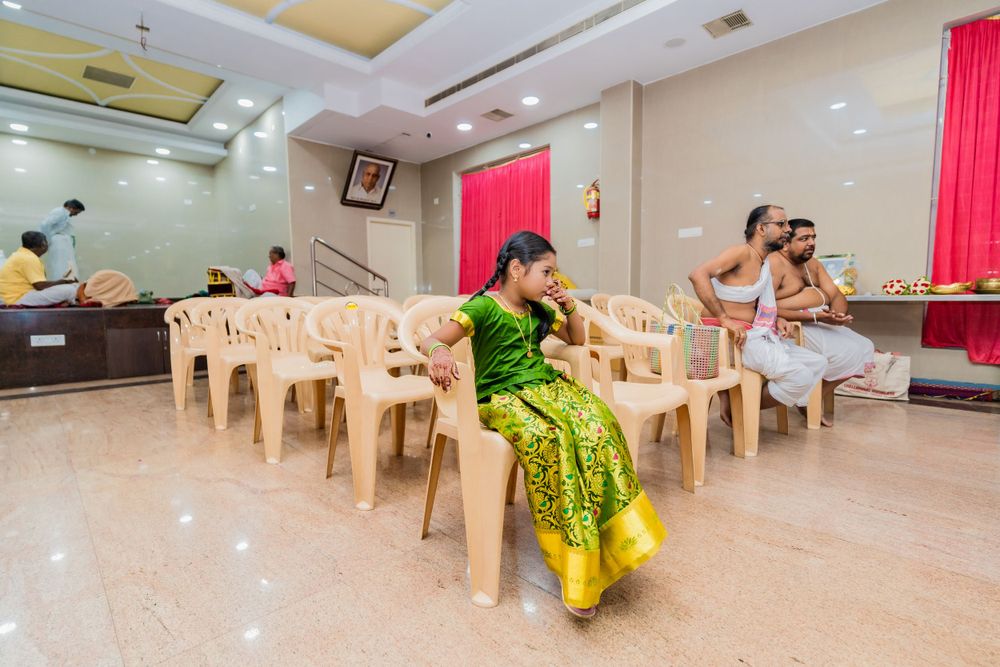 Event hall setup with plastic chairs and red curtain decorations.
