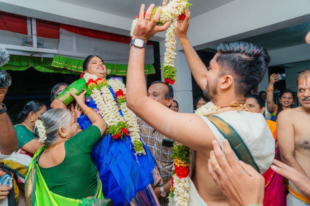 A celebratory ritual moment during an Indian wedding ceremony with flower garlands.