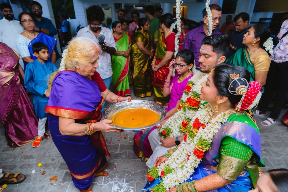 Traditional wedding ceremony with guests offering yellow turmeric powder in a festive gathering.