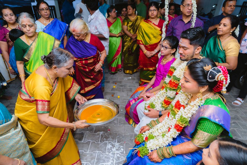 Guests participate in a traditional Indian wedding ritual with colorful powder and decorative garlands.