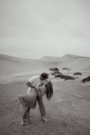 A couple sharing an intimate moment against a misty landscape backdrop.