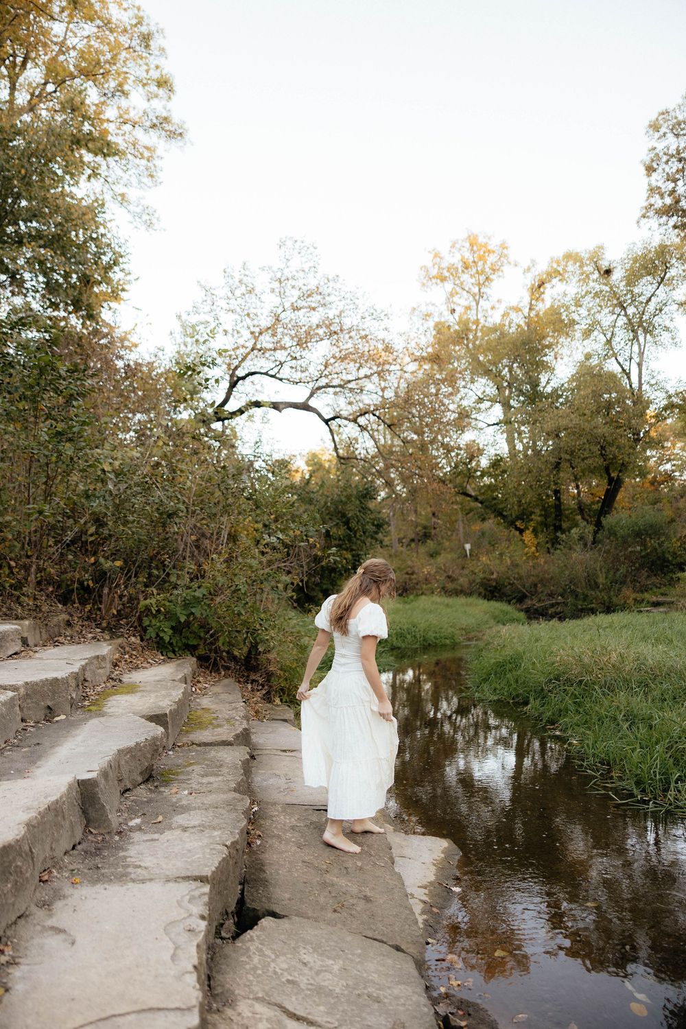 A series of photos showing a stone pathway along a tranquil pond surrounded by autumn trees at sunset.