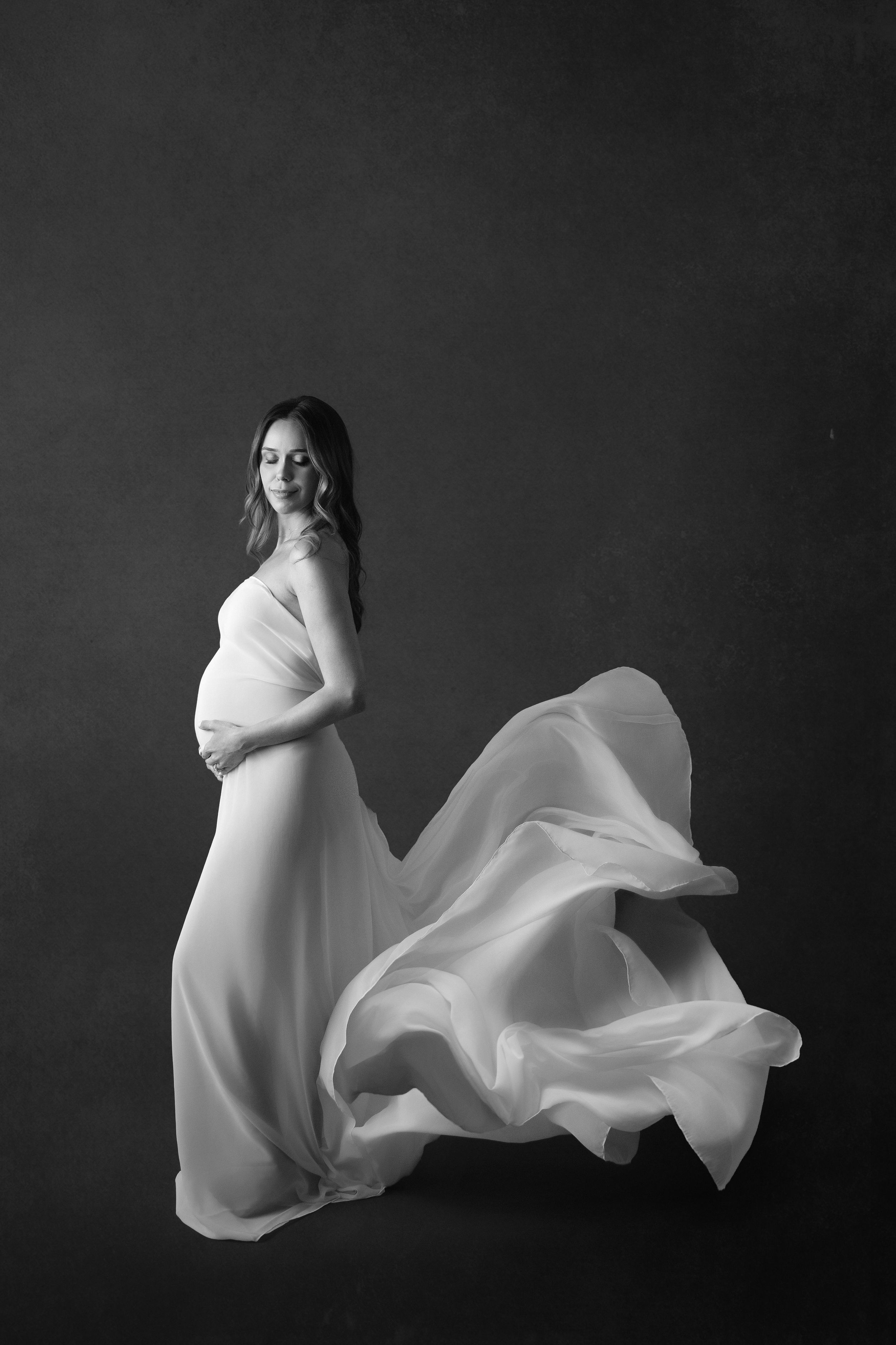A series of black and white artistic photographs showing ethereal white fabric flowing gracefully against a dark background.