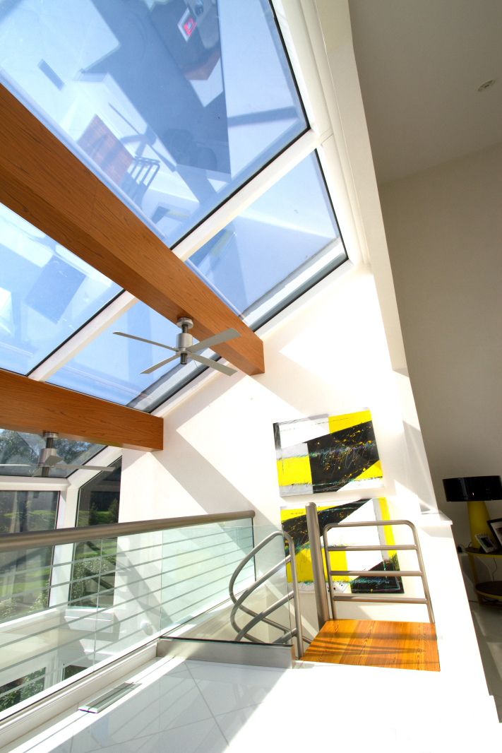 Contemporary architectural detail showing angular skylight with wooden beams and glass panels.