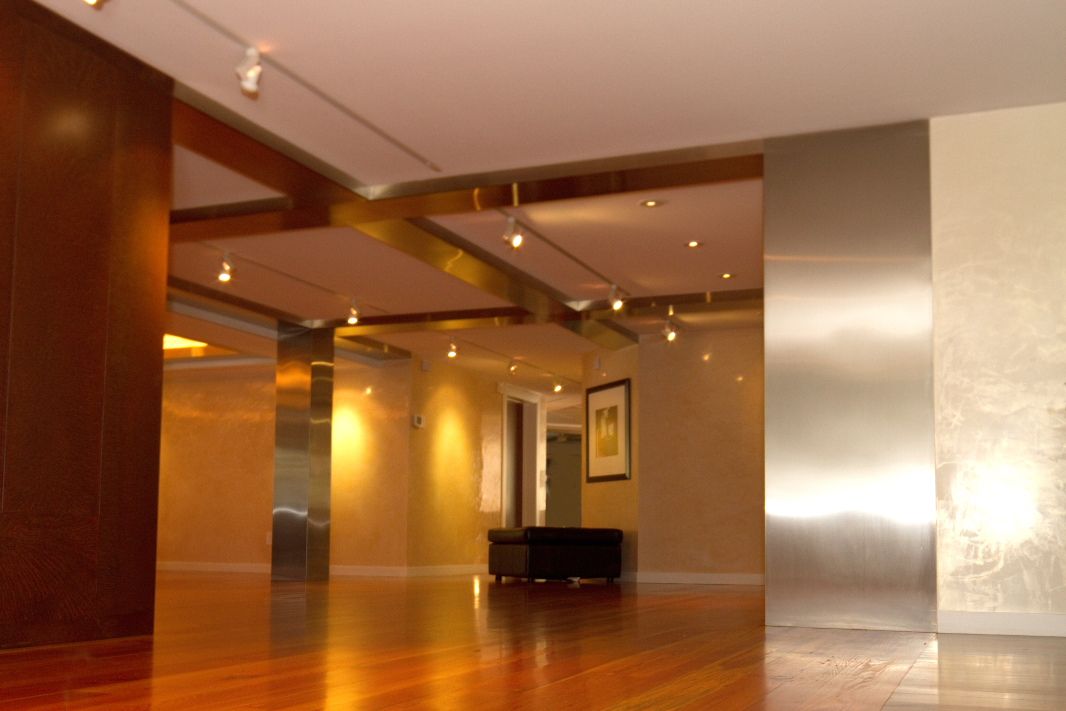 Elegant lobby interior with wood paneling, recessed lighting and modern furnishings.