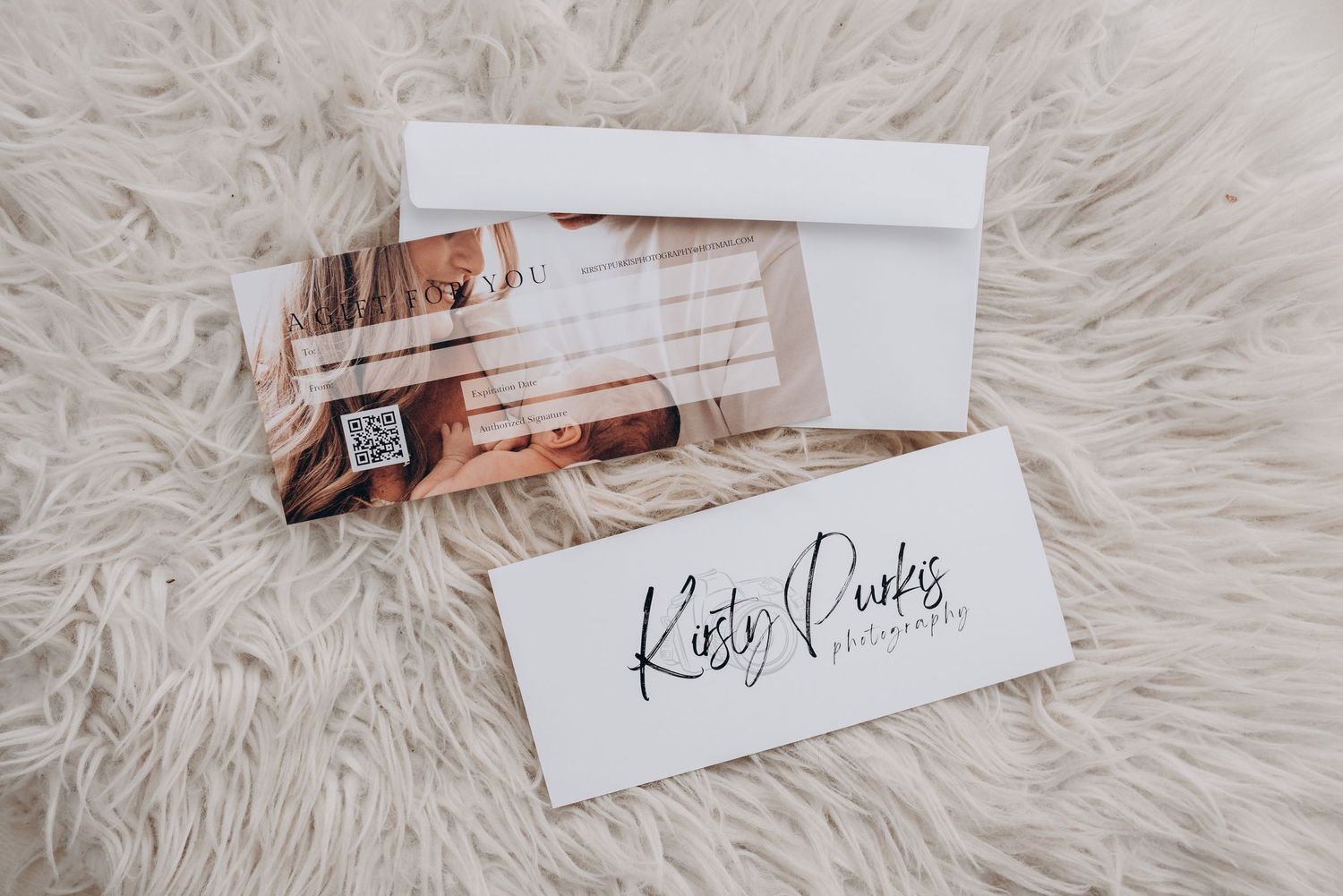 Business cards with elegant script logo displayed on white fur background.