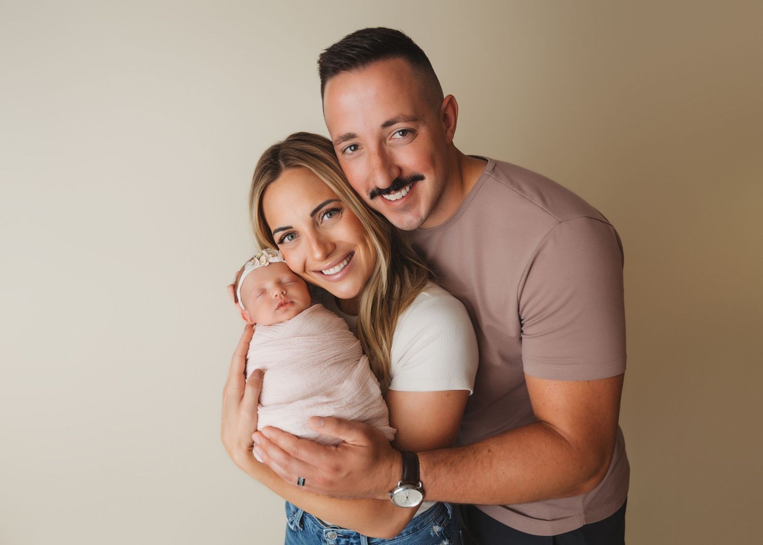 Family lifestyle portrait session against neutral beige studio backdrop.