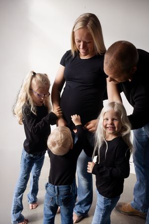 A series of playful black and white photos showing a family interacting and laughing together against a light background.