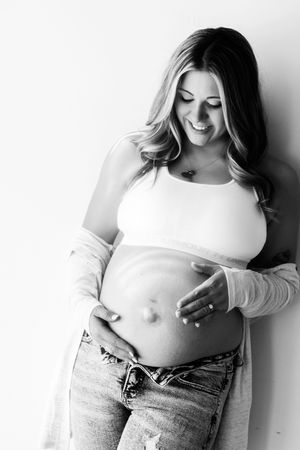 Black and white artistic photo series showing a cropped torso in jeans and white top with playful poses.