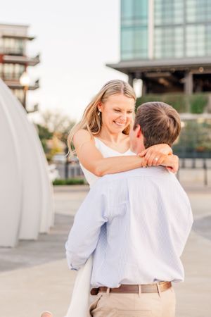 A couple shares a romantic embrace in an urban setting during sunset.