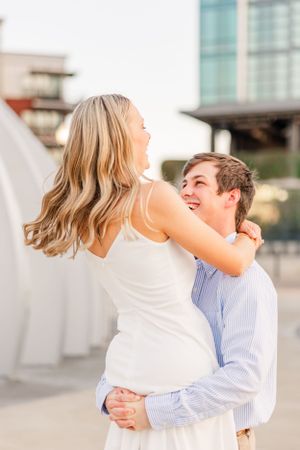 A joyful couple laughs together during their engagement photo session.
