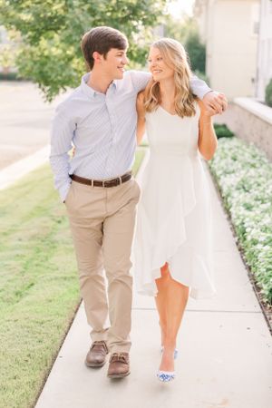 Couple walking together on sidewalk wearing coordinated casual summer outfits.