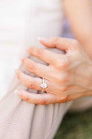 Close-up of an elegant diamond engagement ring on a woman's hand.