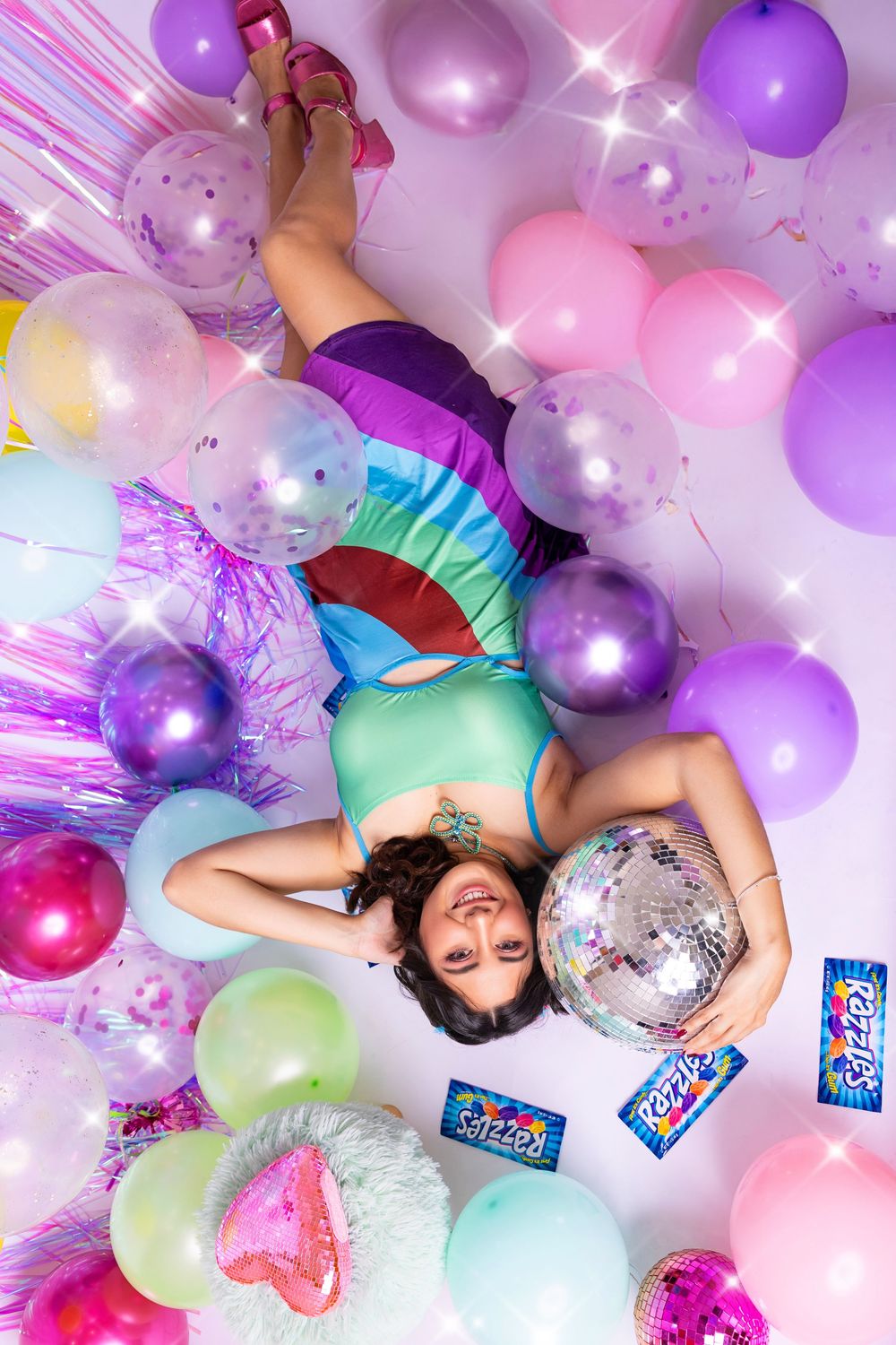 Dreamy pastel balloon photoshoot with disco balls and pink and purple decorations creating a whimsical party atmosphere.