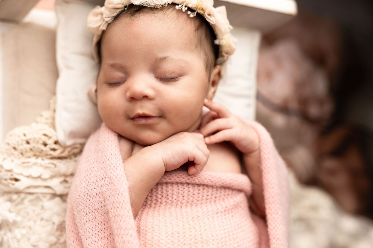 Close-up newborn portraits with pink knit wraps and vintage lace accents.