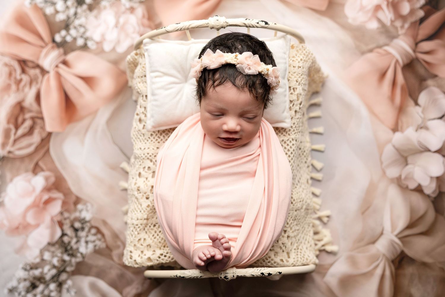Artistic newborn portraits with pink and cream floral accents.