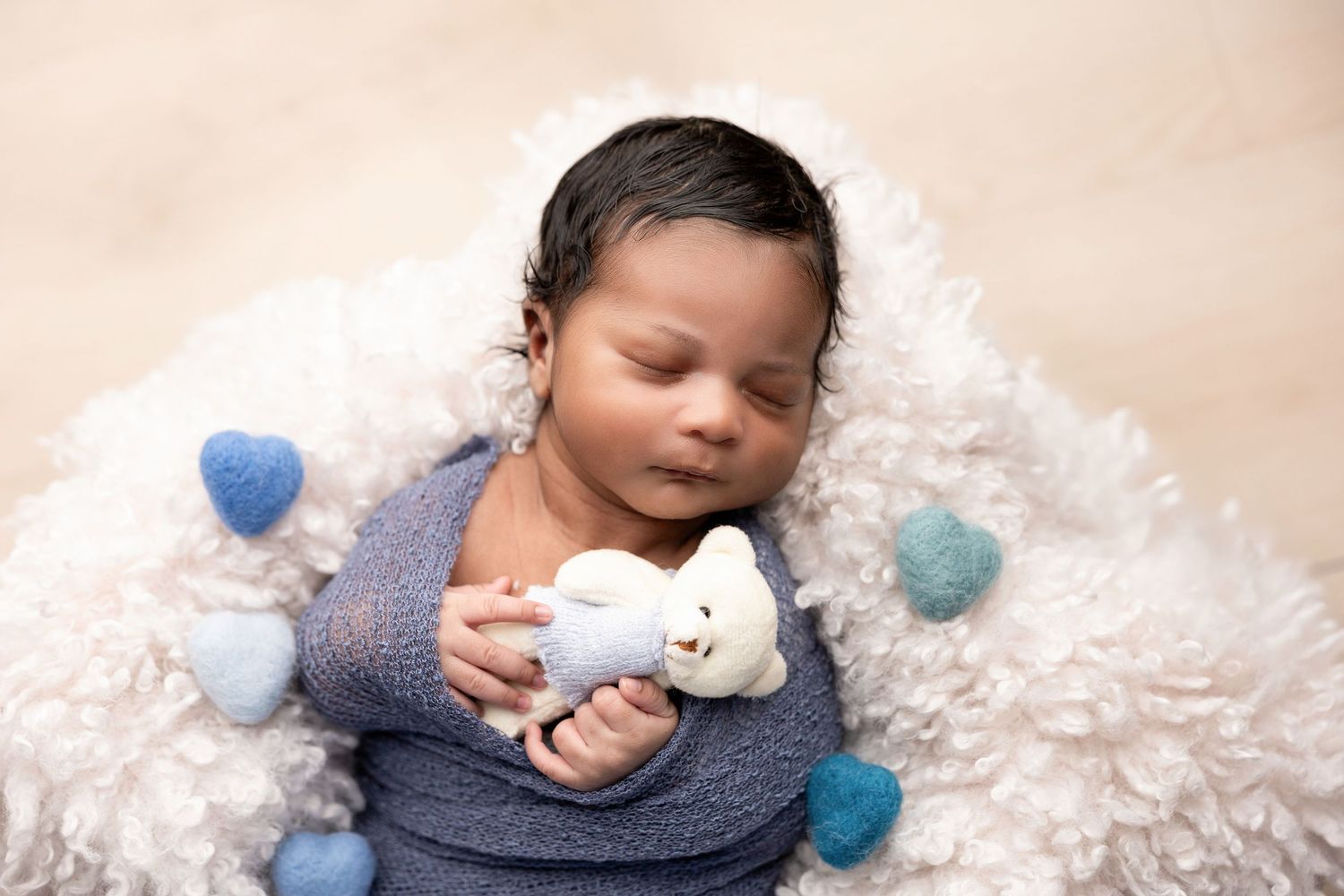A peaceful newborn photography session with soft white and blue accents.