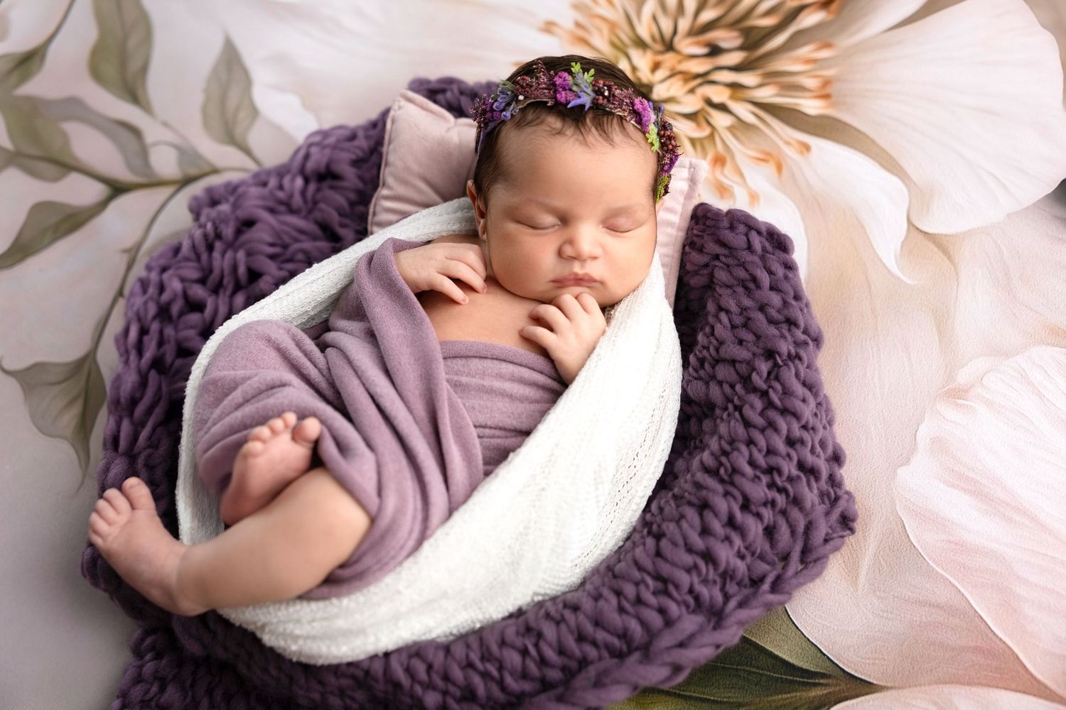 Artistic newborn portraits with purple knit textures and soft white fabric accents.