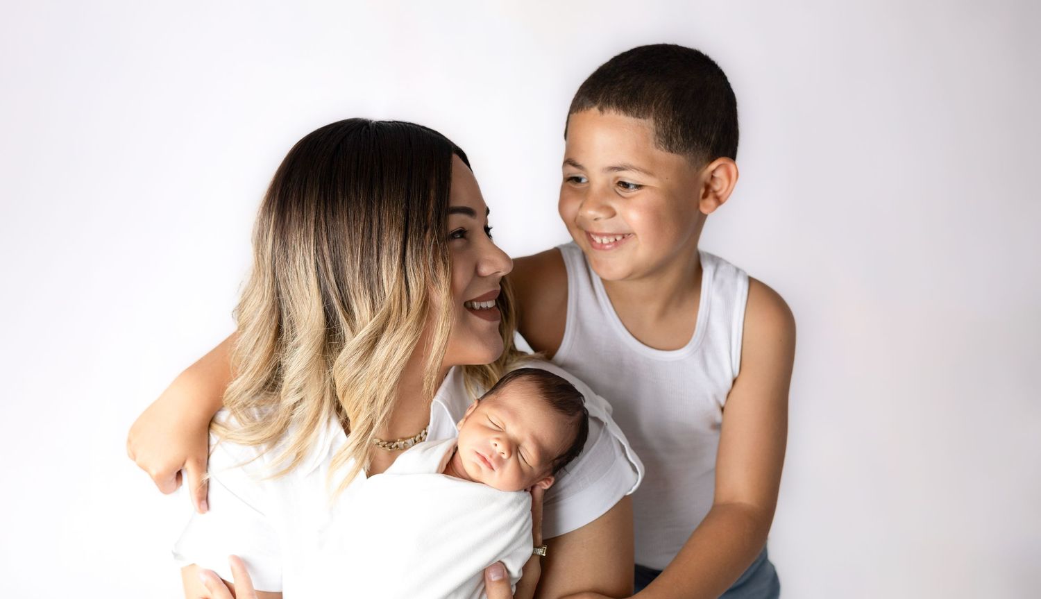 Intimate family portrait on white background showing tender moment.