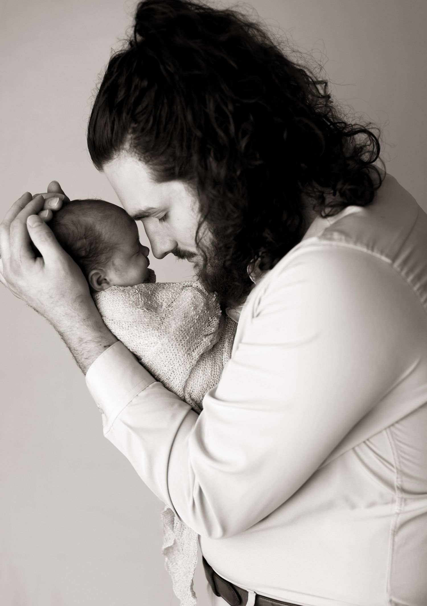 Black and white series of tender moments between parent and newborn.
