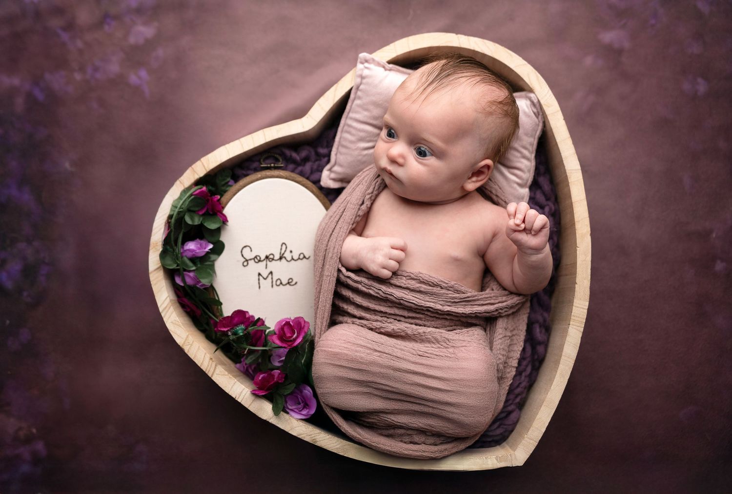 Collection of artistic newborn photos with soft beige wrapping and dark background.