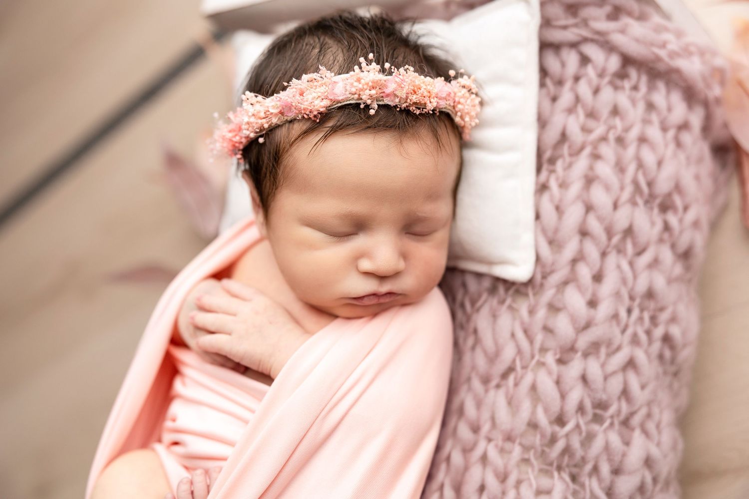 Sweet newborn baby wearing pink outfit in various sleeping poses.