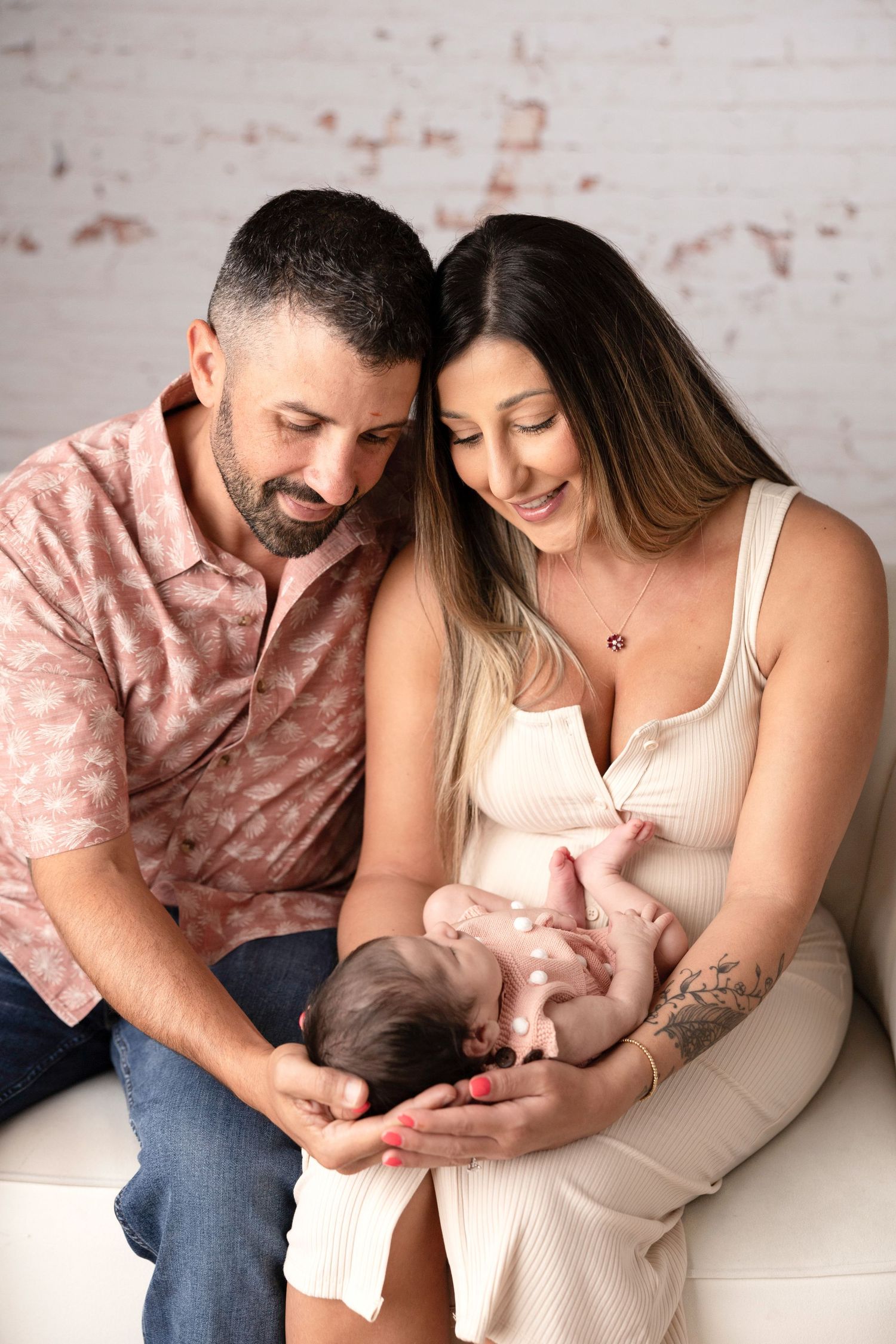Tender family moment captured on white couch during photo session.