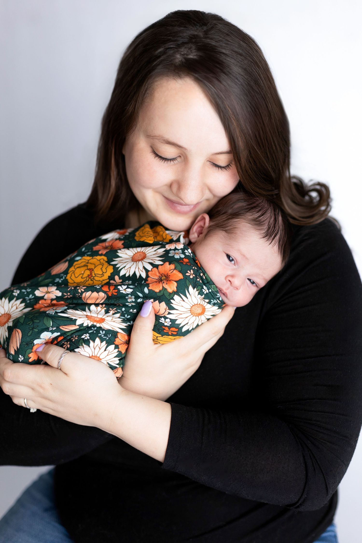 Studio portrait series showing tender embraces between parent and child in floral shirt.