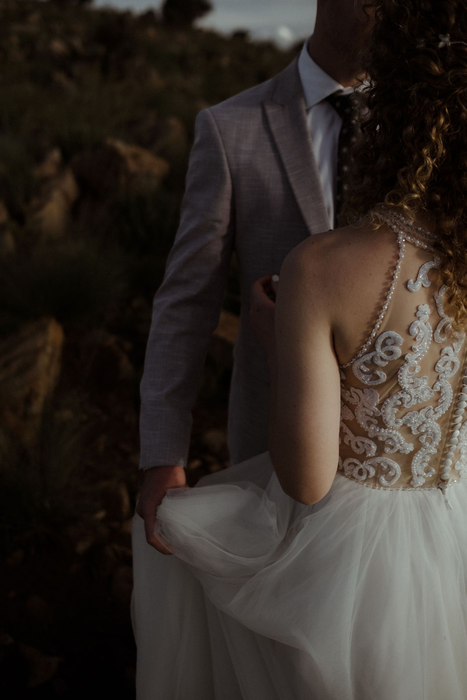 Groom holding bride's dress while standing close to her, Intiem Weddings Pretoria elopement weddings