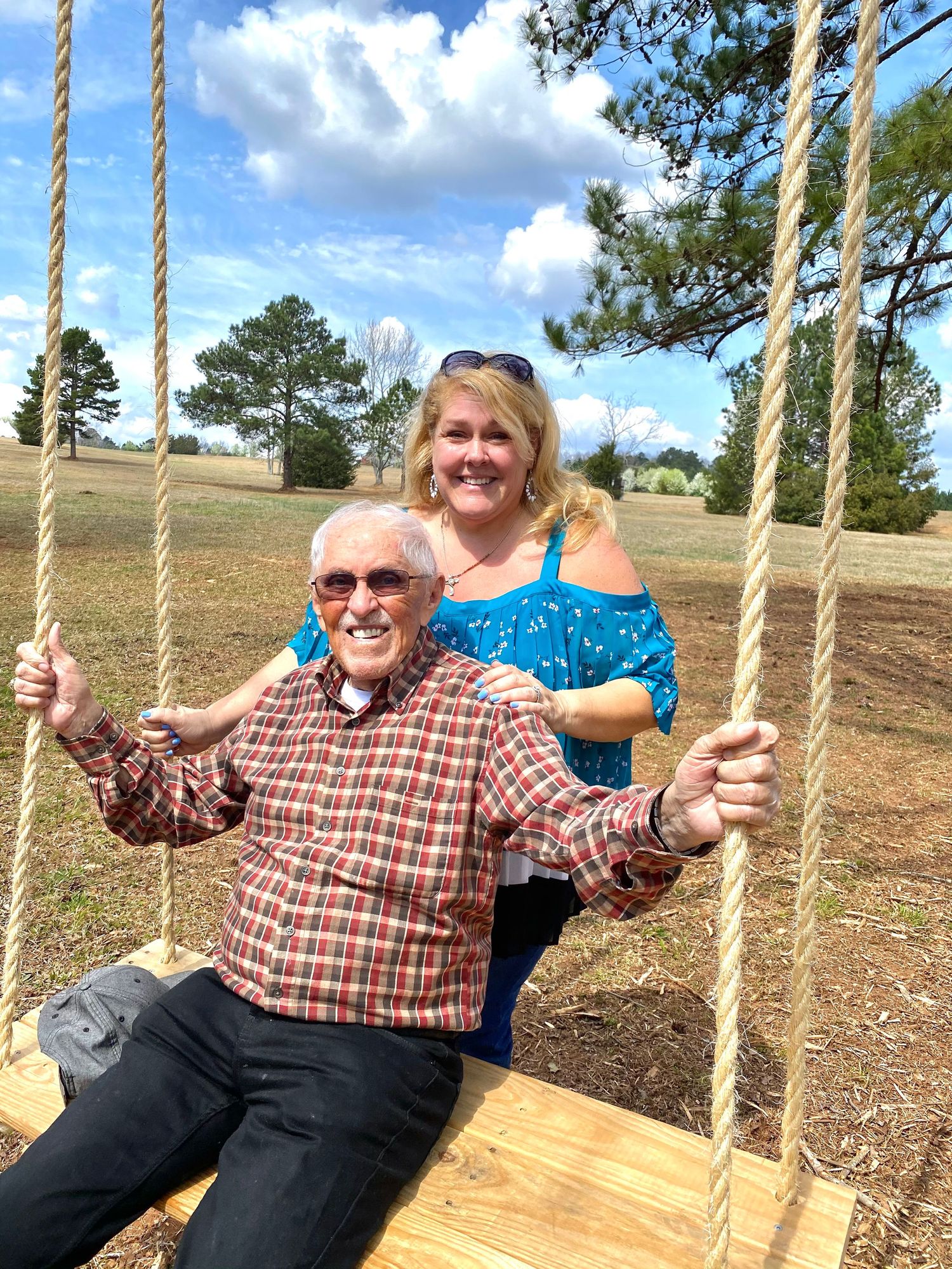 Father and daughter portrait with swing in field
