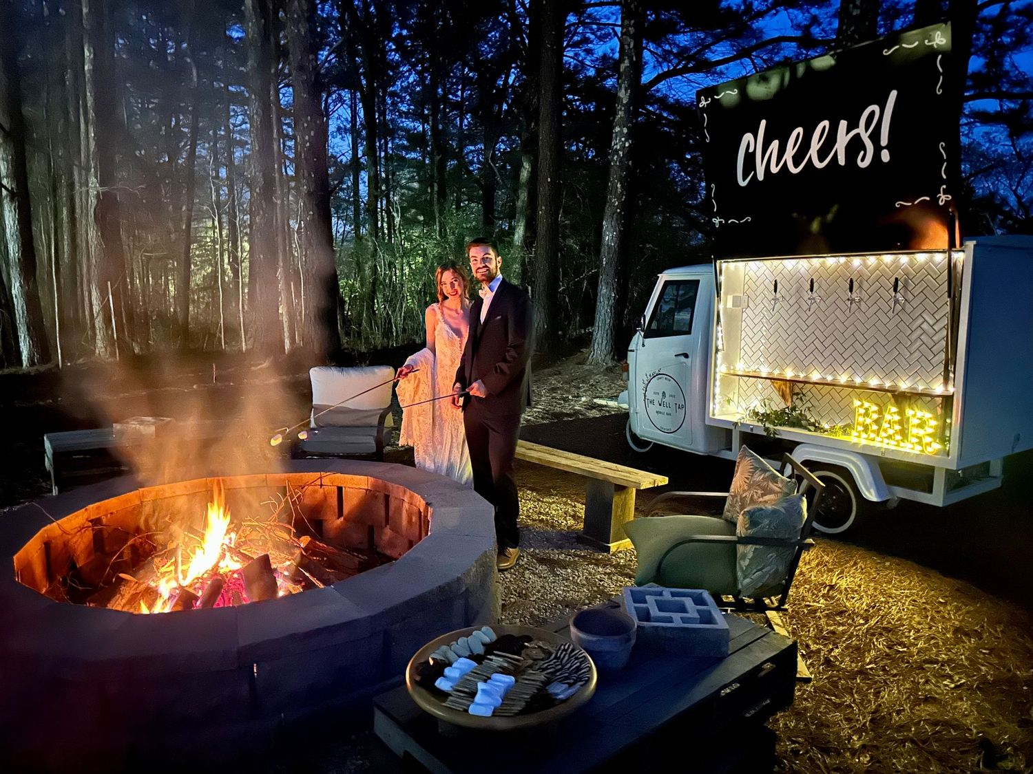 Newly married couple making smores by a firepit after wedding