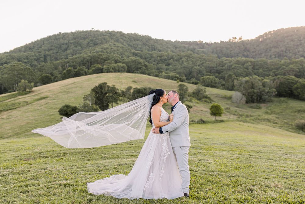 Scenic mountain wedding photos with flowing white dress and veil catching the breeze.