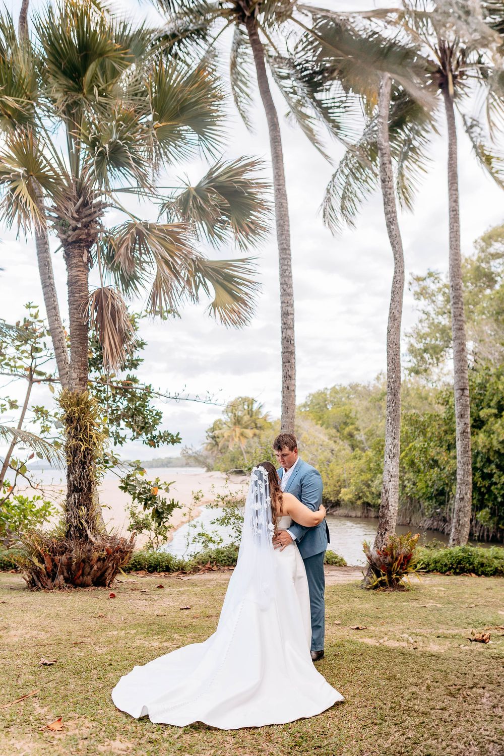A scenic outdoor wedding venue surrounded by palm trees and natural landscaping.
